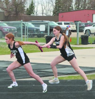 On the last leg of the JH Girls 4X100 Relay, Cynthia Schulz receives the handoff from Aspynn Nygard, ending with a 6th place finish of 1:03.99. Photo by Jamie Rarick