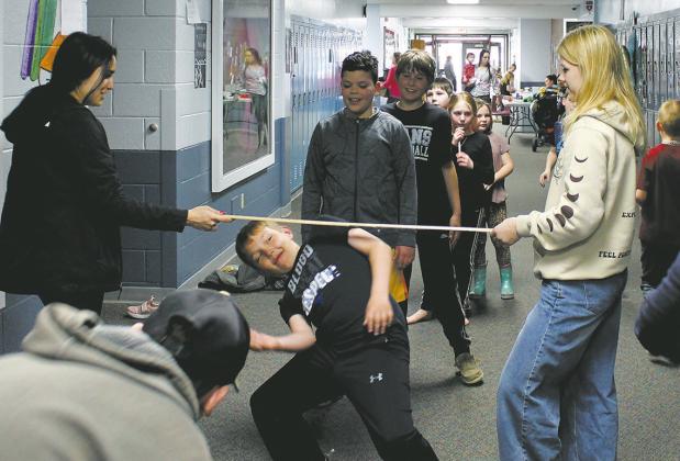 High school students helped with a limbo contest in the halls during Drayton School's family night. Photo by Jamie Rarick