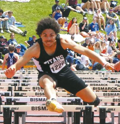 Mason Pollestad leaps over the 110-meter hurdles, placing third at the Class B State Track Meet in Bismarck. Photo by Larry Stokke