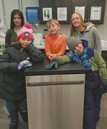 Students from the After-School Program Cooking Class pictured with the new dishwasher purchased with grant funds. Front (L-R) Teagan Taylor and Mikhail Fleishman; Back (L-R) Brooklynne Petersen, Keagan Delohery, and Natasha Shepard. Photo by Shelly Quimby