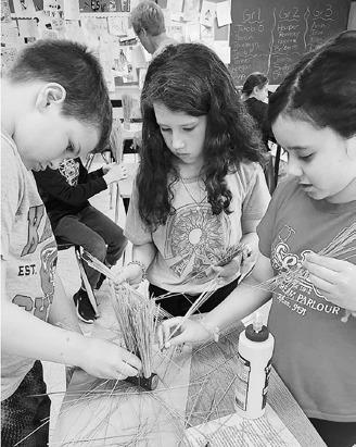 Fourth graders creating handmade brushes during the Pioneer Experience.