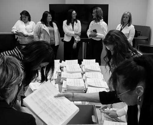 Members of the sponsoring committee for a proposed ballot measure to make public school meals free watch as staff with the North Dakota Secretary of State’s Office count petition signatures on April 9, 2026. Photo by Mary Steurer/North Dakota Monitor