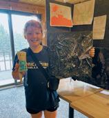 Stella Busse shows off her junk sculpture at the Encore Art Camp. Photo by Jessica Tull.