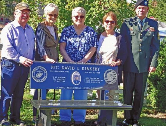 Standing behind the bench placed in honor of David Kirkeby are some of his high school classmates with Drayton Mayor Chip Olson following the flag raising last Wednesday morning. Pictured left to right: Andy Dunklee, Cheryl Gjevre, Mary Lou Kirkeby, Pam Scharmer, and Mayor Chip Olson. Photo submitted by Kirkeby family