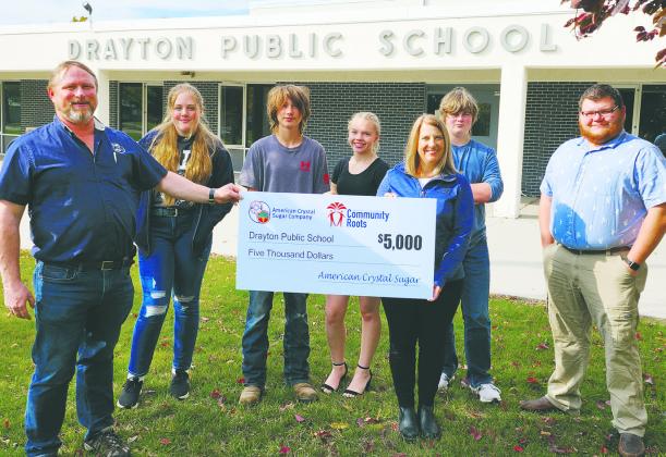 American Crystal Sugar employees present a check for $5,000 to the Drayton Public School ag program. Left to right: Paul Eslinger, American Crystal Sugar Company maintenance superintendent; Lauren Peterson, Hunter Sherrill, Hope Patterson, ag students; Kristi Johnson, American Crystal Sugar Company factory accounting supervisor, Jaxon Wilson, ag student, and Adam Riddle, ag teacher at Drayton Public Schools.
