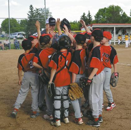 Coach Chase Boen brings the 10U team into a huddle before the start Thursdays game against Park River. Photo by Rebecca Davis