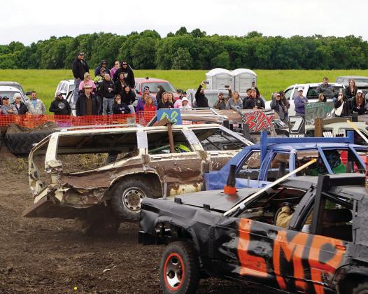 Onlookers watch as the number 08 car leans on two wheels. Photo by Larry Stokke