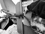 Pinhole leaks in hydraulic hose lines are extremely dangerous and can be impossible to see with the naked eye. Using a piece of cardboard to check for leaks protects hands and fingers. (NDSU photo)