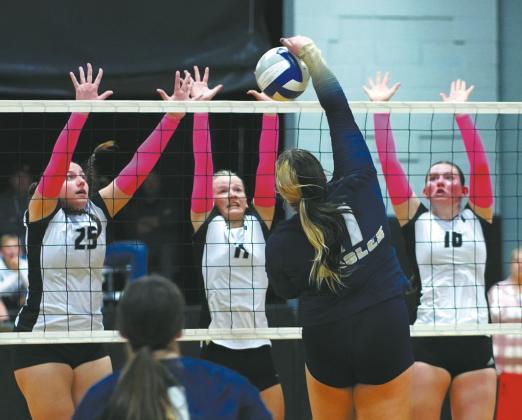DVE seniors Christine O’Toole, Alyssa Hoyles and junior Ingrid Myrdal leap for the block against North Border senior Jaelyn Forrey. Photo by Larry Stokke.