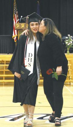 New graduate Justyce Wallery gets kissed on the cheek leaving the commencement ceremony. Photo by Andrea Johnston