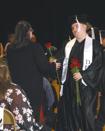 Grant Uggerud handing a rose to his mother during his Graduation ceremony last Sunday Photo by Andrea Johnston