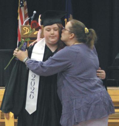 Stephanie Kissee receiving a congratulatory embrace from her mother while leaving graduation. Photo by Andrea Johnston