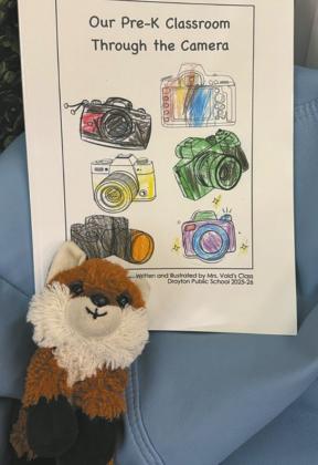 The cover of the book was colored by Mrs. Vold’s class in preparation for publication. The finished book sits with a favorite stuffed animal. Submitted photo
