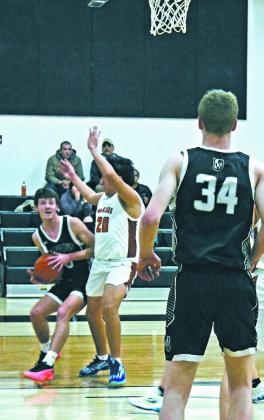 In a drive to the basket, Brady Reilly pushes past Warrior defender Elijah Feather, Jr. Photo by Jamie Rarick.