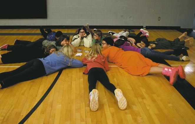 After completing a puzzle challenge during reading month at DPS, the 4th grade class takes time to relax. Photo by Staci Jenson