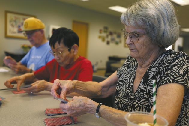 From left, Earl Nelson, Masayo Sollid and Marlys Young, all of Fargo, play a card game with fellow senior citizens on Wednesday, July 2, 2025, at the Ed Clapp Park Senior Center in south Fargo. Anna Paige / The Forum