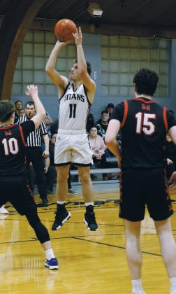 Midway-Minto's Trenton Sitzer tries to defend the hoop against DVE senior Isaac Feltman. Photo by Jamie Rarick