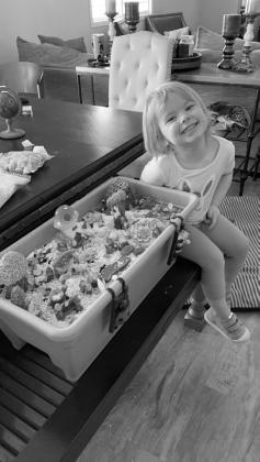 LeeAnn’s granddaughter, Charlee, posing with a fairy garden they created together. Photo by Christine Jenson.