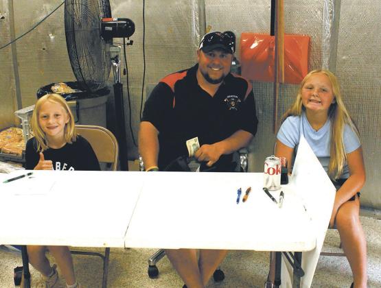Drayton fire chief Jordan Grundstrom with helpers Charlotte Schumacher and Marissa Grundstrom greeted guests at the door for Thursday's burger night. Photo by Jamie Rarick
