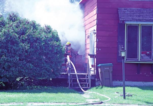Drayton Volunteer Fire Department works in blistering heat to battle a house fire on Third Street last Friday afternoon.