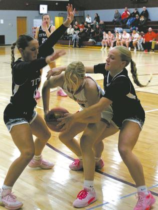 DVE's Jacey Nelson and Reese Fering fight for the ball against a Midway-Minto ball carrier. Photo by Jamie Rarick