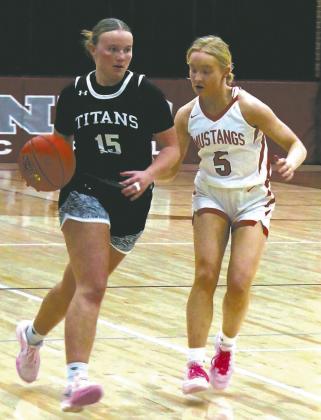 DVE senior Aleah Pokrzywinski moves the ball down court while being guarded by Midway-Minto senior Bre Hurt. Photo by Jamie Rarick