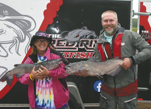 First-place winners May Thompson of East Grand Forks and Jayson Ackerson of West Fargo show off two of their Day 2 catches, weighing 18.83 and 16.41 pounds. The pair brought 41.31 pounds to the scales on Day 2 and finished the Drayton Catfish Capital Tournament with a winning two-day total of 76.68 pounds. Photo by Rob Boll