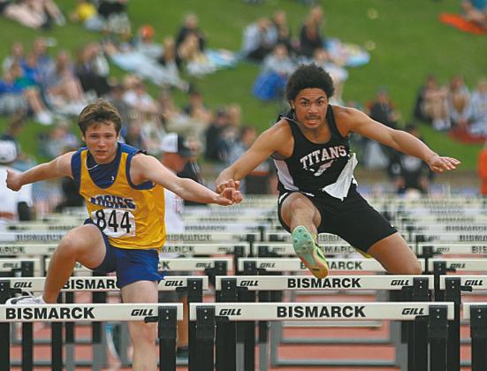 D-V-E’s Mason Pollestad, right, runs side by side with Velva’s Brady Hoff during a preliminary heat in the Boys’ Class B110 Meter Hurdles at the State Track Meet in Bismarck on Friday. Photo by Mike Alan Steinfeldt