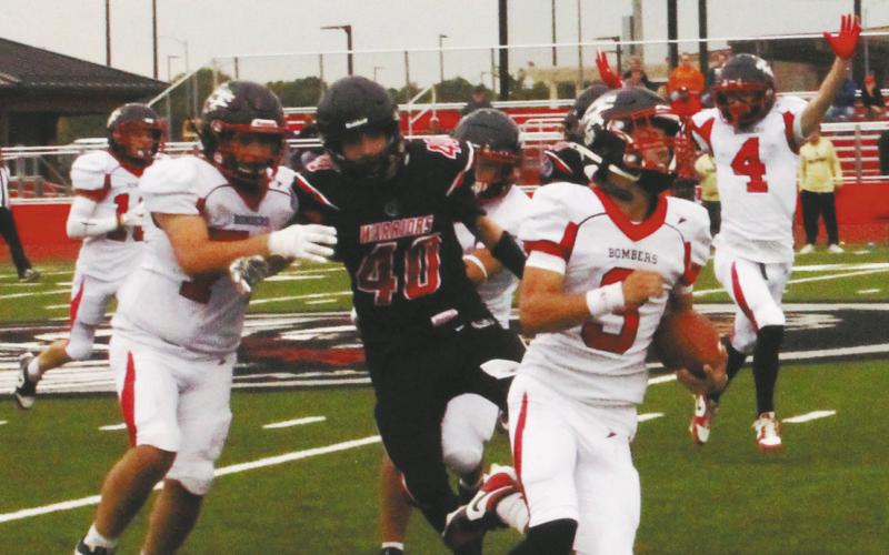 Flanked by his teammates, Trenten Keena carries the ball for another Bomber touchdown. Photo by Jamie Rarick