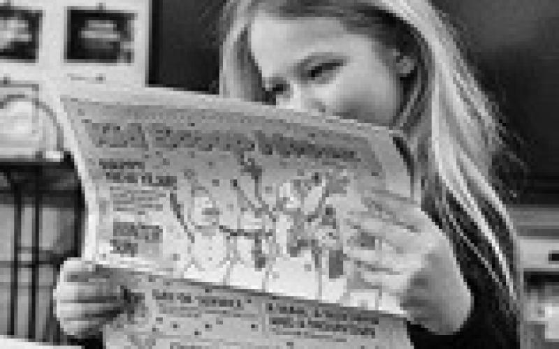 Arianna Nygaard reads the latest Kid Scoop News. Photo by Cecile Wehrman, The Journal.