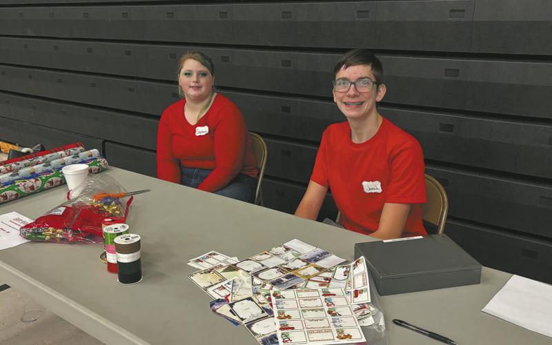 Stephanie Kissee and Jonah Rarick manned a gift wrapping station in the Drayton Gymnasium during the Crafters Market. Photo by Andrea Johnston