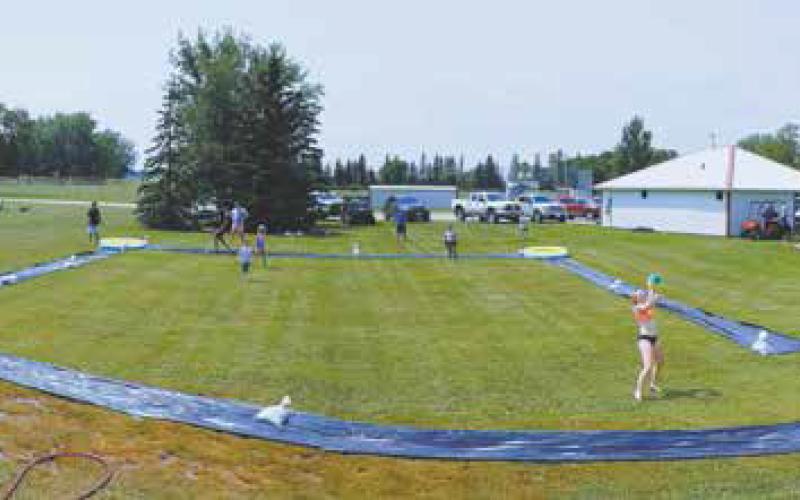 Slip ‘N’ Slide had a huge-turn out at Schumacher Park last Friday. An anonymous donor sponsored the entire event, quote, “for the kids.” This is the second year and the plan is to have the event every year. Photo by Duane H.H. Lyon