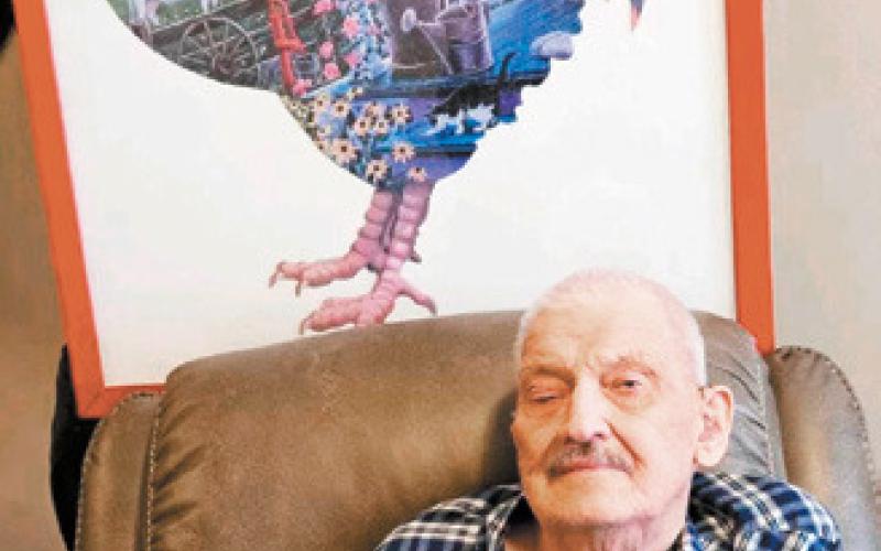 Bobby is photographed here with one of his many completed puzzles that he loves working on. Photo submitted by Arlen Westling.