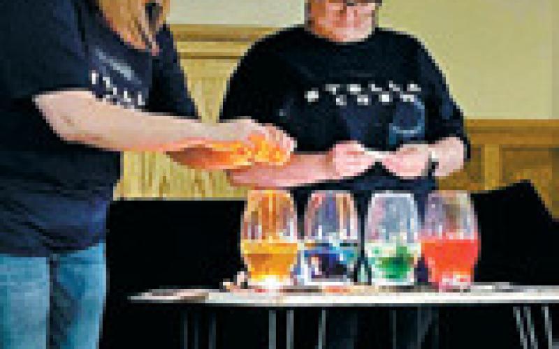 Angie Aasand and Bryanna Halvorson perform a science experiment in front of VBS groups. Photo by Cindy Johnson.