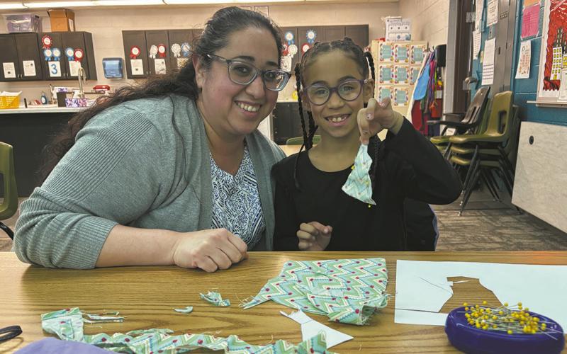 The youngest member of the club, Mia Johnson is making a Barbie prom dress with the assistance of her mother, Yvonne. Photo by Andrea Johnston