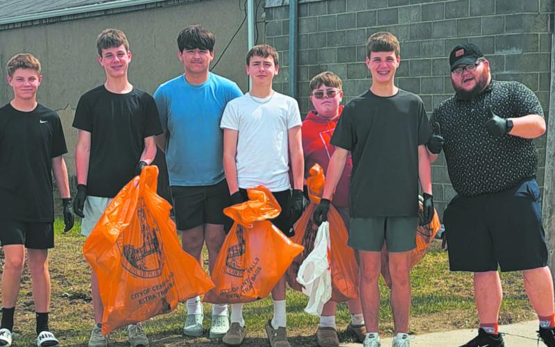 Mr. Riddle gives a thumbs up as his group shows off their bounty of collected trash. Photo by Christine Jensen