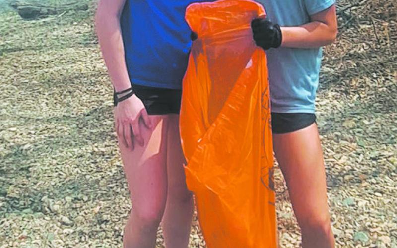 Students pick up trash along the boat launch on the Red River. Photo by Christine Jensen