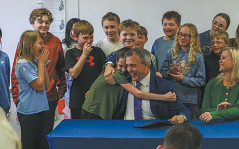 A student at Centennial Elementary gives Gov. Kelly Armstrong a hug after he gave her the pen he used to sign House Bill 1160, which requires North Dakota public schools to adopt phone-free school policies, on Friday, April 25. Submitted photo.