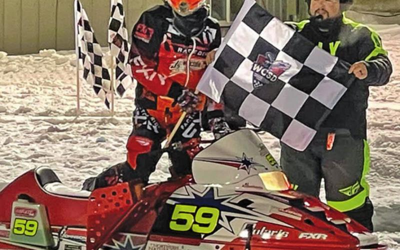 Hunter Johnson poses with the flag at Eagle River. Photo submitted by Johnson Racing