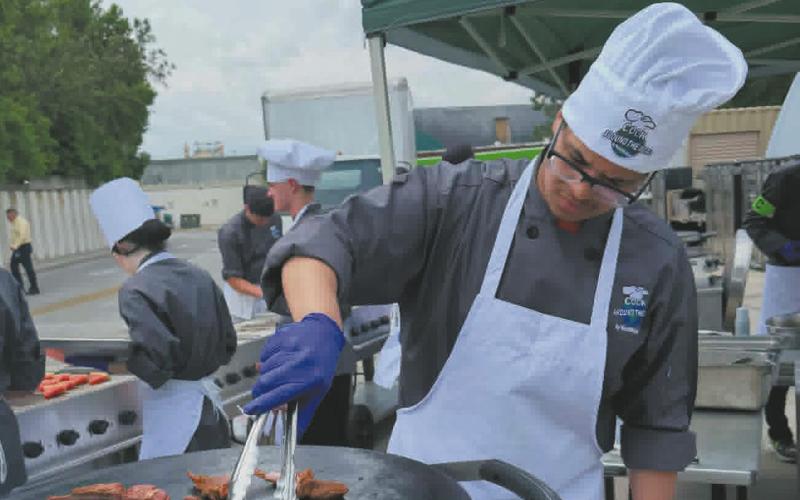 Jerimiah Johnson prepares lamb chops for his entree. Photo by Yvonne Johnson.