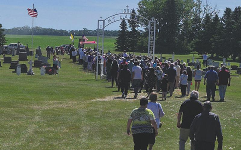 A procession through the cemetery followed the final mass held last Sunday. Reverend Schill discussed how the Our Lady Mt. Carmel Cemetery Fund is currently at $40,000, but needs to be closer to $100,000 to be a viable, lasting foundation. Photo by Hilary Nowatzki.