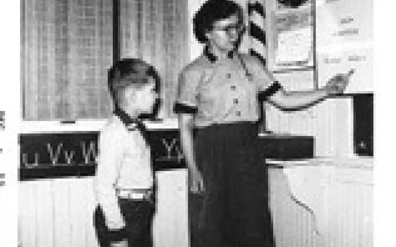 Clint is pictured here in the school year of 1955-56 with his first grade teacher, Carol Hoselton, who taught him how to read and write at Morrison District 13 north of Drayton.