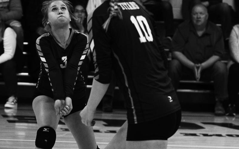 Junior Claire Thompson (3) passes the ball as sophomore Easton Larson gets ready to hit in Friday's final match of the year vs. North Border in Pembina. Photo by Mike Alan Steinfeldt.