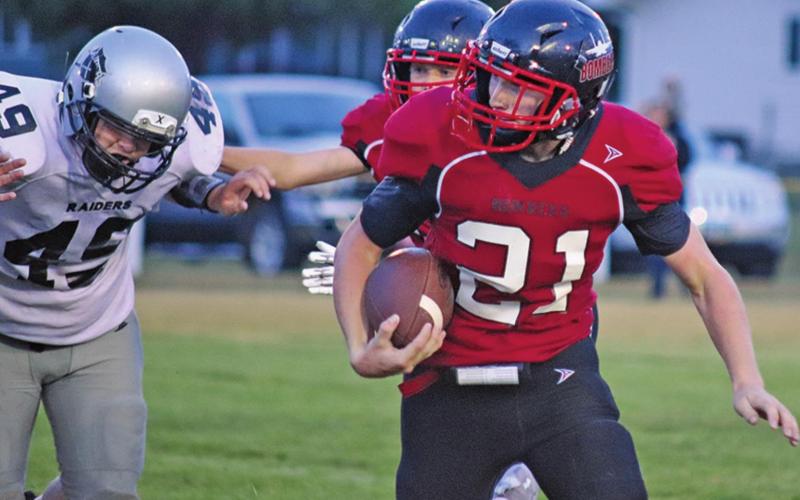 Cayden Quibell runs the ball while Raider Zach Volson is being slowed from getting the tackle Friday night on the Drayton field. VNV photo by Lesa Van Camp