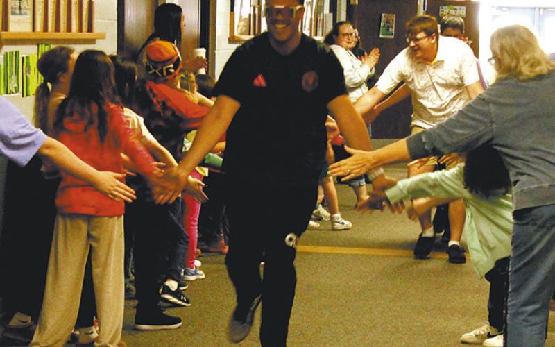 Daniel De Souza, gives high five’s for luck while leaving for the state music competition. Photo by Jamie Rarick
