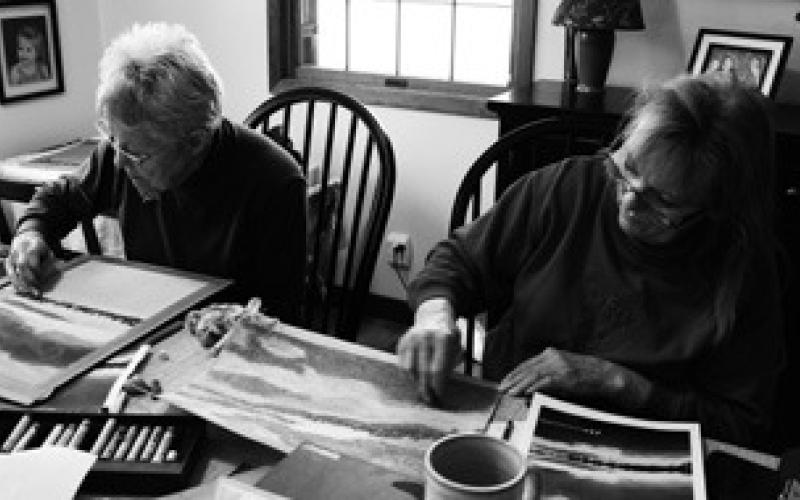 After completing their base layer of oil pastels, Laurel Brusseau (left) and Sylvia Moore (right) brainstorm on how to bring out the finer details in their works. Photo by Mary Ellen Kirking.
