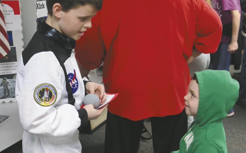 Calvin Helm is entertained by his big brother Henry Helm's presentation about the first astronaut on the moon, Neil Armstrong. Photo by Jamie Rarick