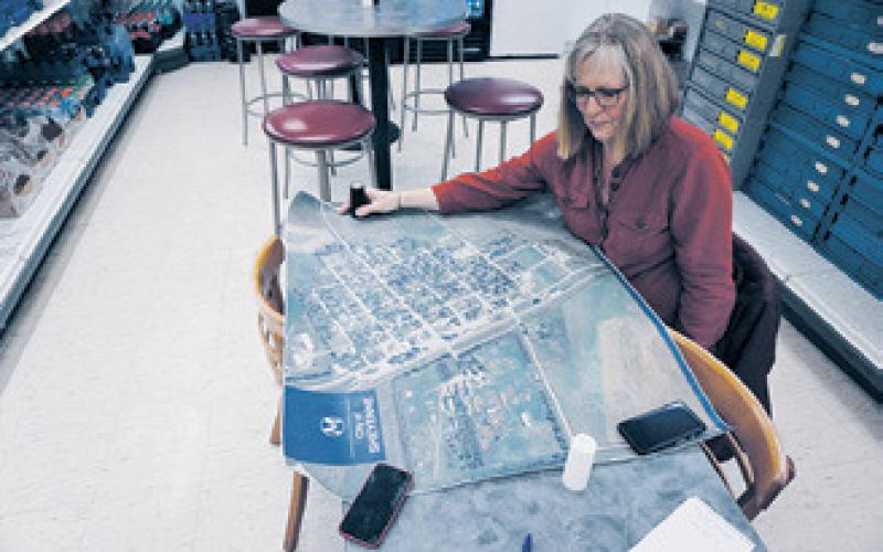 Patti Larson displays a map of the town of Sheyenne at a back table at Route 281 Repair and Convenience on Feb. 13, 2023. Photo by Michael Standaert.