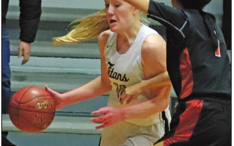Meghan Lorton heads for the basket to put up two while being defended by Warrior Bethany Brown. VNV Photo by Lesa Van Camp