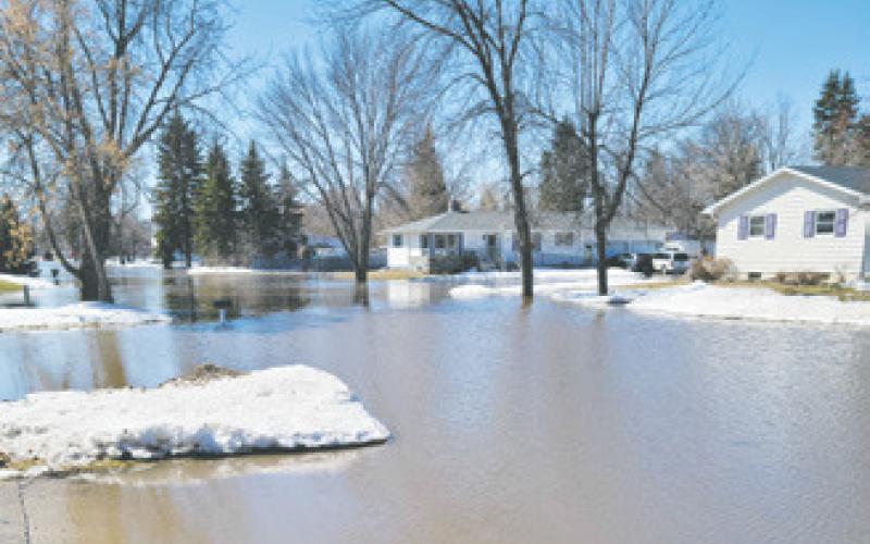 This picture was taken looking south along First Street in Minto on Monday. Water from overland flooding caused the Forest River at Minto to spike to more than 3 feet above flood stage prompting closure of Highway 81. Many residents needed to sandbag their homes in an attempt to keep the water out. Photo by Mike Alan Steinfeldt.